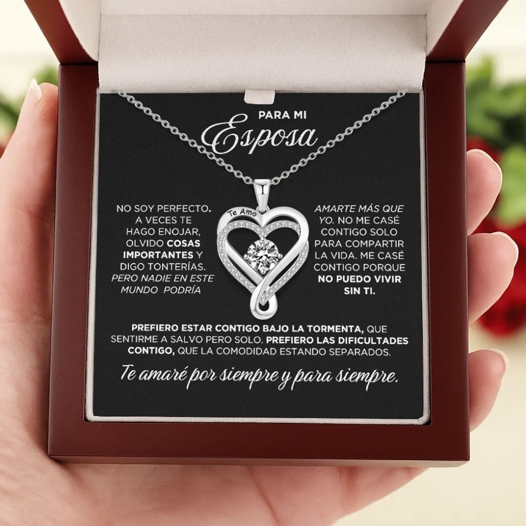 Una mano sostiene un joyero abierto con el "Collar - A mi Esposa" y un mensaje en español para una esposa, que expresa amor, compromiso y el deseo de afrontar juntos los retos: un regalo ideal para parejas.
